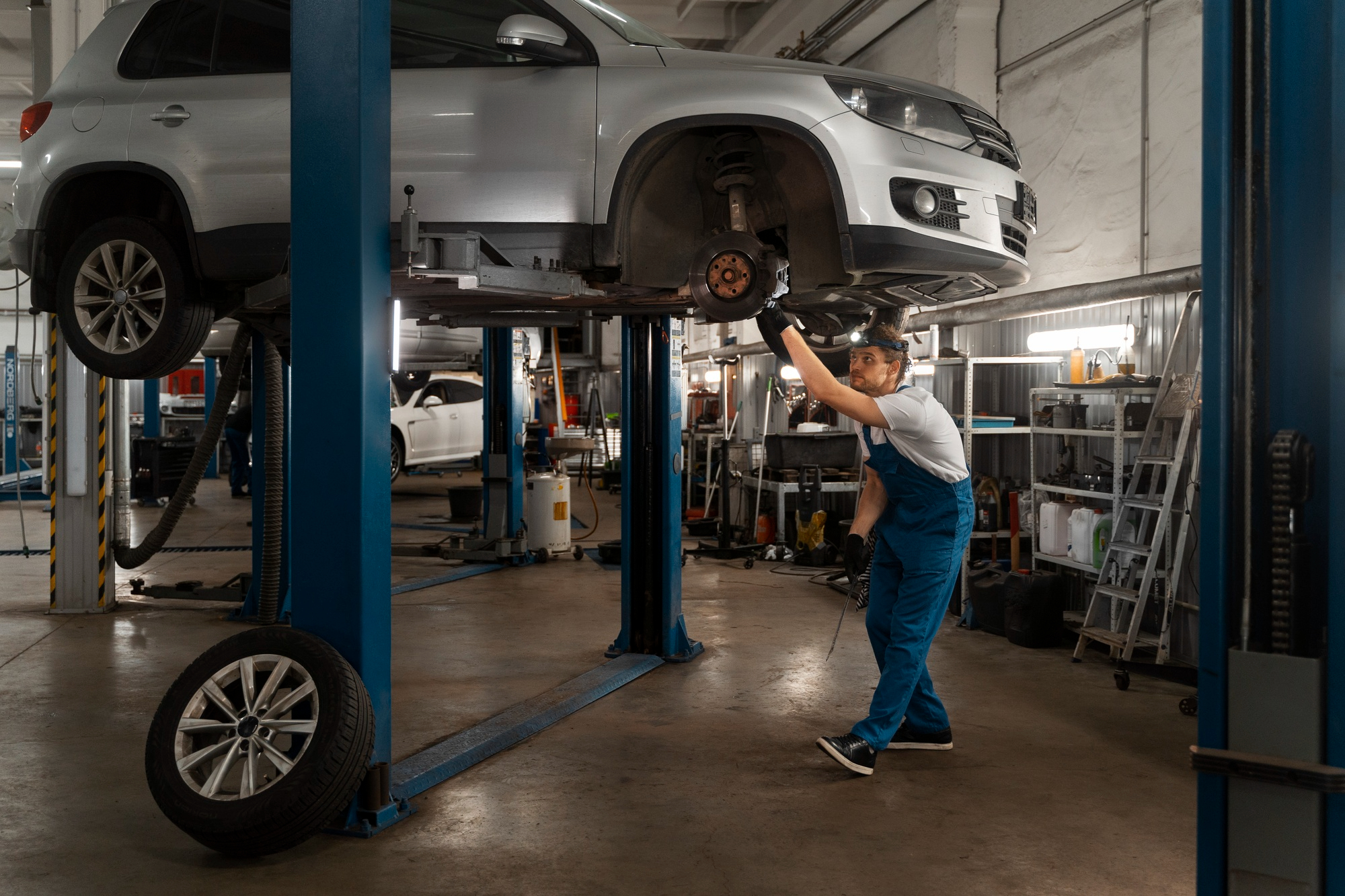 Mechanic repairing undercarriage of vehicle